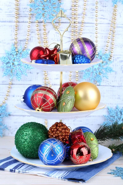 Різдвяні прикраси на десертній підставці, на кольоровому дерев'яному фоні — стокове фото