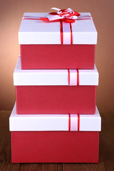 Beautiful gift boxes on table on brown background