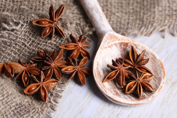 Star anise in wooden spoon, on wooden background — Stock Photo, Image