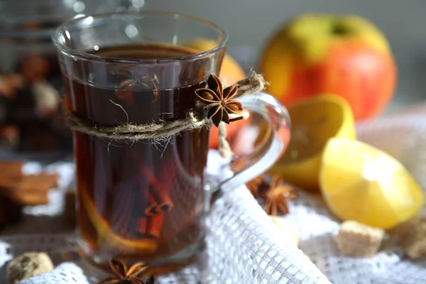 Warme drank in glas cup met vruchten en specerijen, op houten achtergrond — Stockfoto