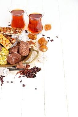 tepsi ve Beyaz ahşap zemin üzerinde çay bardak lezzetli oryantal tatlılar