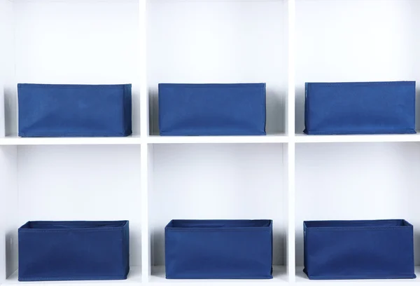 Blue textile boxes in white shelves — Stock Photo, Image