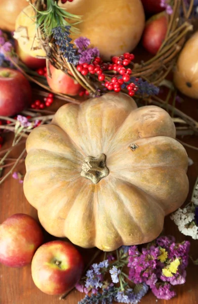 Herbstliche Komposition aus Äpfeln, Kürbissen, Blumen und trockenen Zweigen auf Holztisch in Großaufnahme — Stockfoto