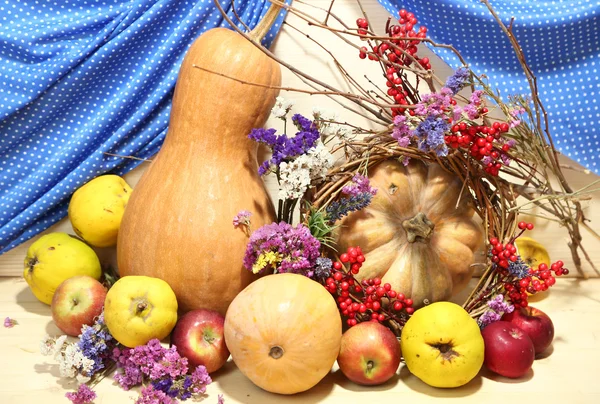 Осінній склад яблук, гарбузів, квітів і сухих гілок на дерев'яному столі на дерев'яному фоні — стокове фото