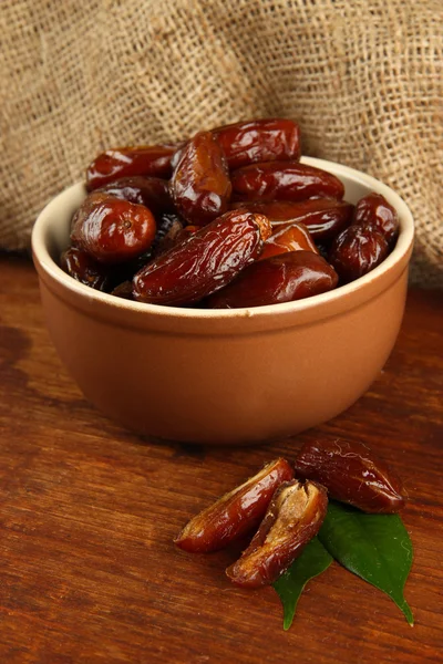 Dried dates in bowl on table on sackcloth background — Stock Photo, Image