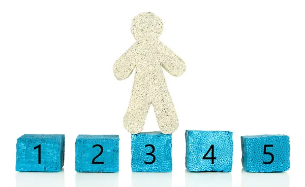 Malý muž a stavební kameny s čísly izolovaných na bílém — Stock fotografie