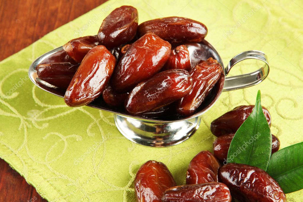 Dried dates in metal dish on fabric background Stock Photo by