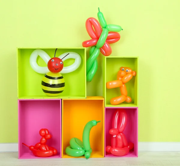 Globo simple animales y otros juguetes en estantes, sobre fondo brillante — Foto de Stock