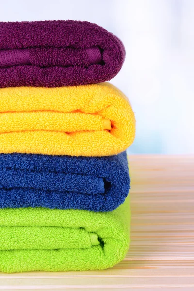 Bright towels on table on light background — Stock Photo, Image