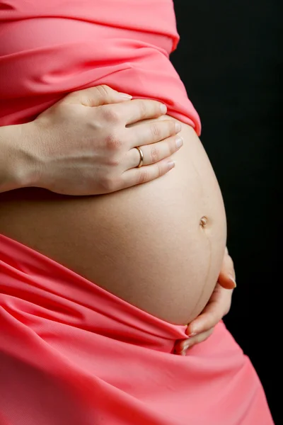 Kobieta w ciąży z korala materiał z bliska — Zdjęcie stockowe