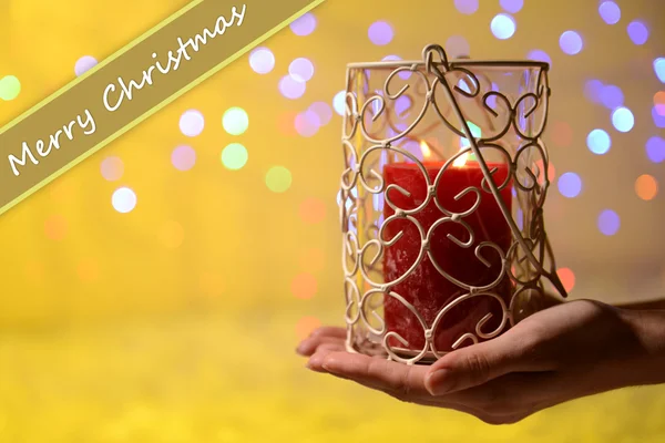 Candle in hand on blur lights background — Stock Photo, Image