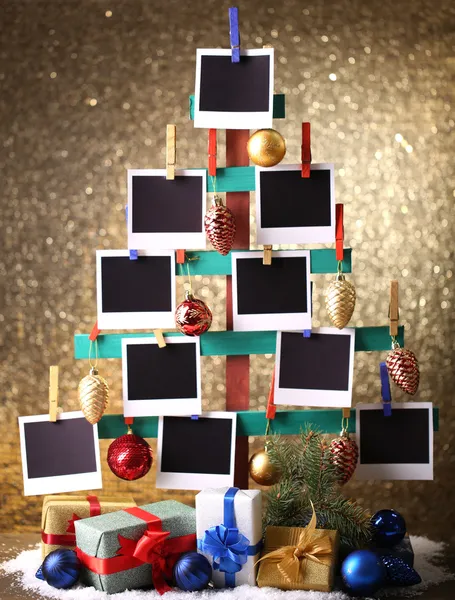 Mão de madeira feita de abeto com papel fotográfico vazio e decoração de Natal no fundo brilhante — Fotografia de Stock