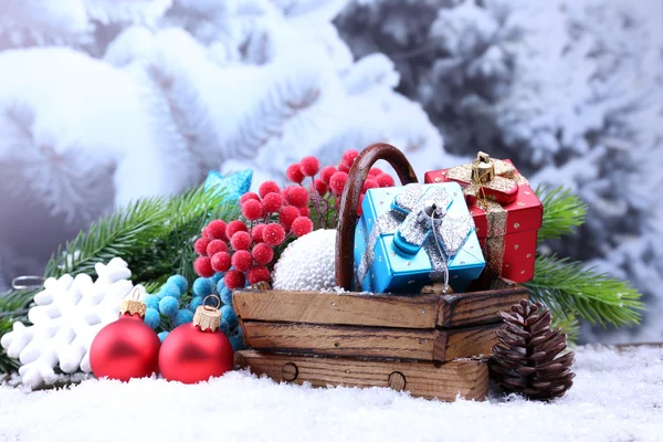 Composición con decoraciones navideñas en cesta, abeto sobre fondo claro — Foto de Stock
