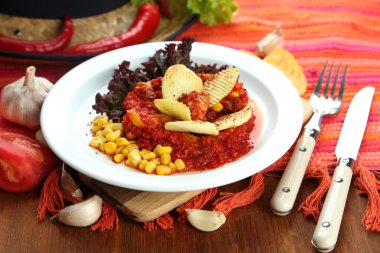 Chili Corn Carne - traditional mexican food, on white plate, on napkin, on wooden background clipart