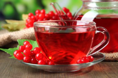Bodegón con té de viburnum en servilleta de tela de saco, sobre fondo de madera