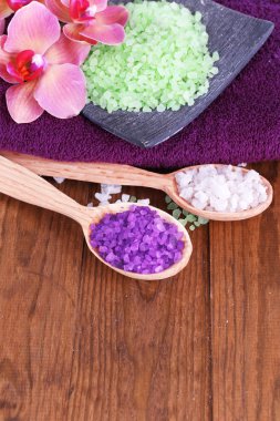 güzel çiçek ile natürmort orkide çiçek ve renk ahşap zemin üzerinde deniz tuzu ile tahta kaşıklar