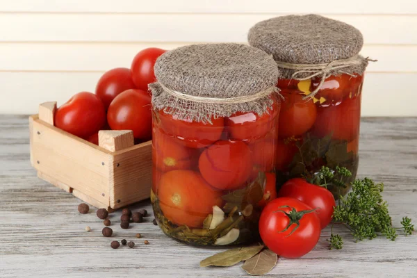 Chutné konzervy a čerstvá rajčata na dřevěný stůl — Stock fotografie