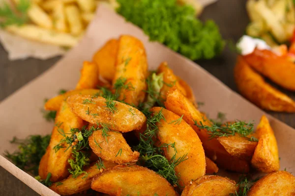 Home potatoes on tracing paper on wooden table — Stock Photo, Image