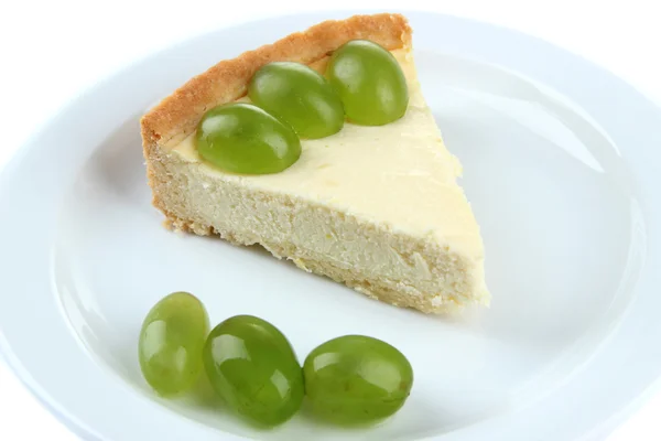 Fatia de cheesecake com bagas de uva no prato, isolado em branco — Fotografia de Stock