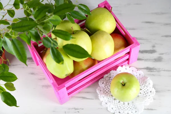 Saftige Äpfel in Schachtel auf Holztisch — Stockfoto