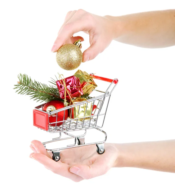 Mão segurando presentes de Natal no carrinho de compras, isolado em branco — Fotografia de Stock