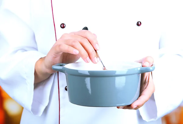 Padella in cuoco mani su sfondo luminoso — Foto Stock
