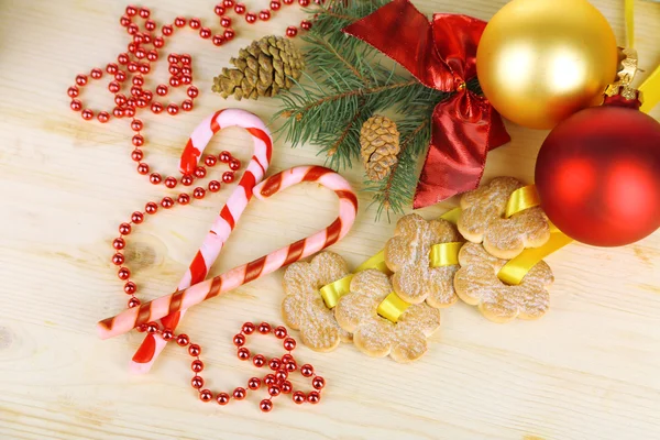 Biscoitos em fitas com decorações de Natal em mesa de madeira — Fotografia de Stock