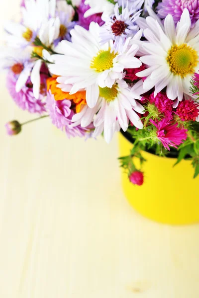 Flores silvestres en taza sobre mesa de madera — Foto de Stock