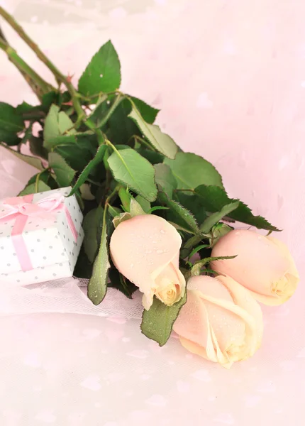 Hermosas rosas y regalo en tela rosa, de cerca —  Fotos de Stock
