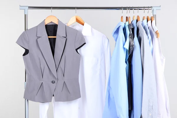 Office kleren op hangers, op grijze achtergrond — Stockfoto