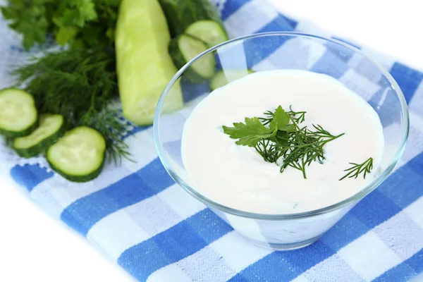 Salatalık üzerinde beyaz izole renkli peçete üzerinde cam kase yoğurt — Stok fotoğraf