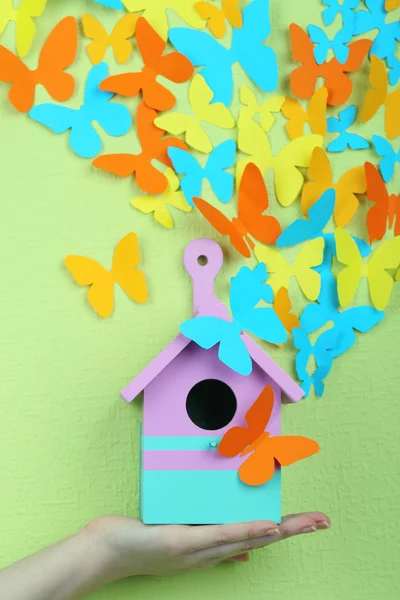 Papier papillons volent hors du nichoir sur fond de mur vert — Photo