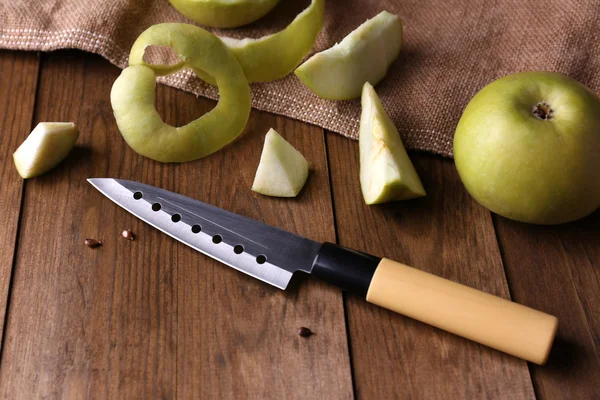 Mutfak bıçağı ve yeşil elma, ahşap arka planda. — Stok fotoğraf
