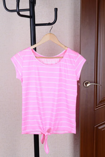 T-shirt hanging on hanger near door — Stock Photo, Image