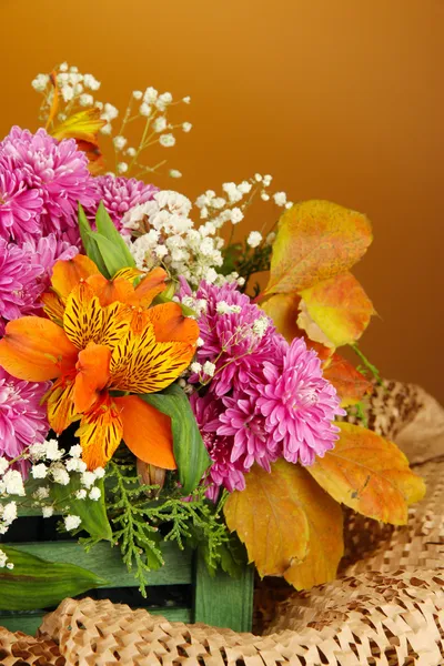 Квіти композиція в ящику на столі на коричневому фоні — стокове фото