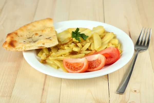 Patatas fritas en plato sobre mesa de madera primer plano — Foto de Stock