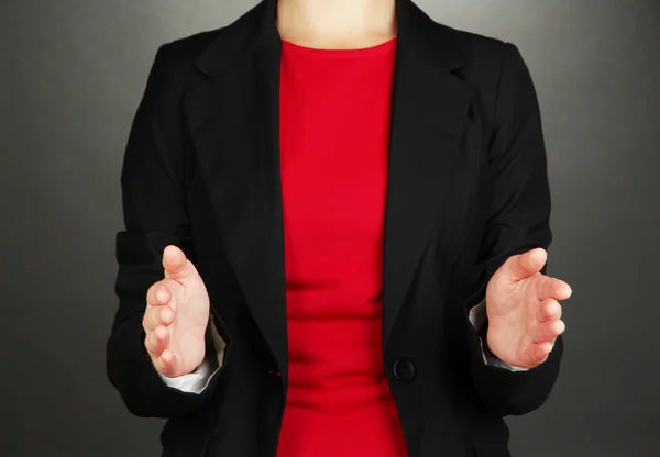 Mani femminili che mostrano qualcosa su sfondo grigio — Foto Stock