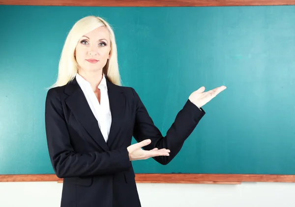 Professora da escola perto de quadro negro em sala de aula — Fotografia de Stock