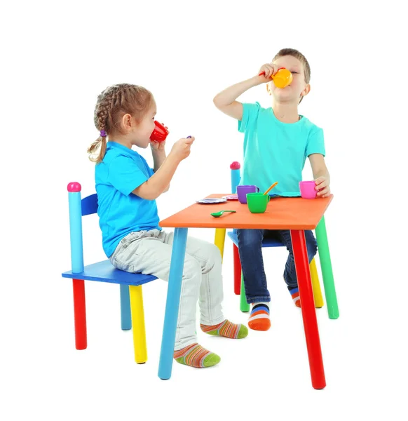 Crianças brincando com utensílios de mesa coloridos isolados em branco — Fotografia de Stock