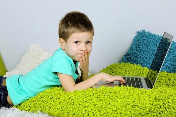 Kleine jongen met laptop op bed — Stockfoto