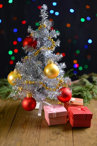 Árbol de Navidad decorativo con regalos en la mesa sobre fondo brillante —  Fotos de Stock