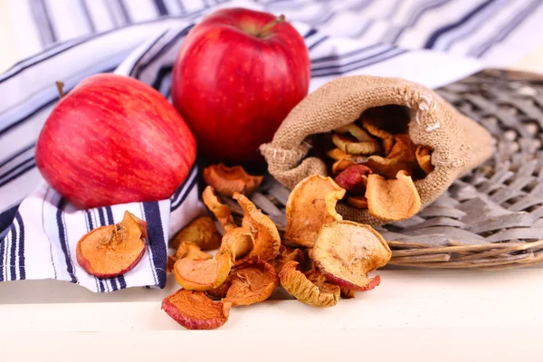 Dried apples and fresh apples, on napkin, on white wooden background — Stock Photo, Image