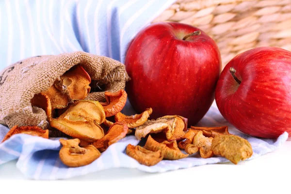 Pommes sèches et pommes fraîches, sur serviette, sur fond de bois blanc — Photo