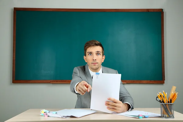 Junge Lehrerin sitzt im Klassenzimmer — Stockfoto