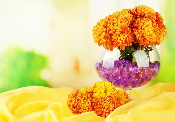 Красивые цветы в вазе с гидрогелем на столе на ярком фоне — стоковое фото