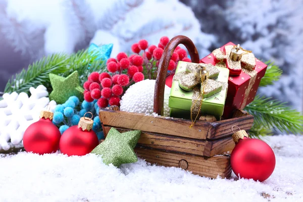 用篮子里的圣诞装饰品、浅色背景的冷杉树作曲 — 图库照片
