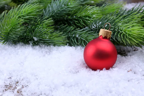 Christmas ball and fir tree on light background — Stock Photo, Image