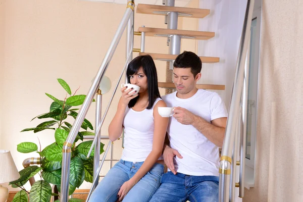 Молодая пара, сидящая на лестнице в новом доме — стоковое фото