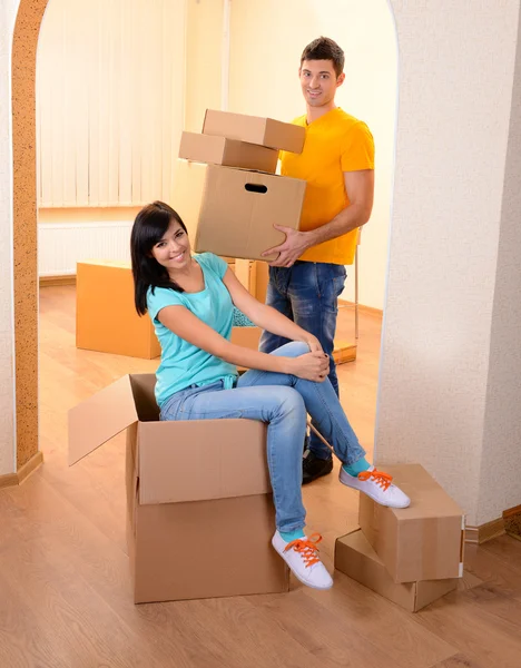 Young couple fooling around in new house on room background — Stock Photo, Image