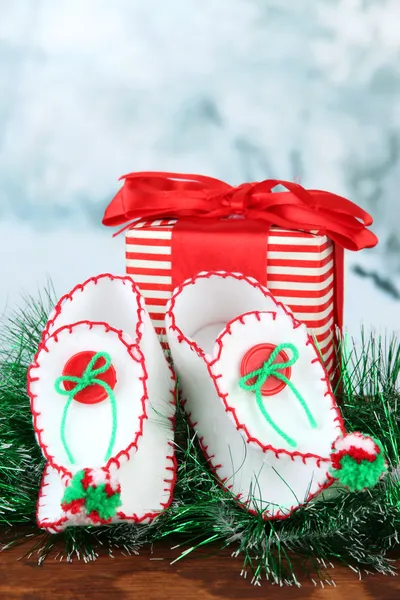 Decorative Christmas shoes with present on table on bright background — Stock Photo, Image